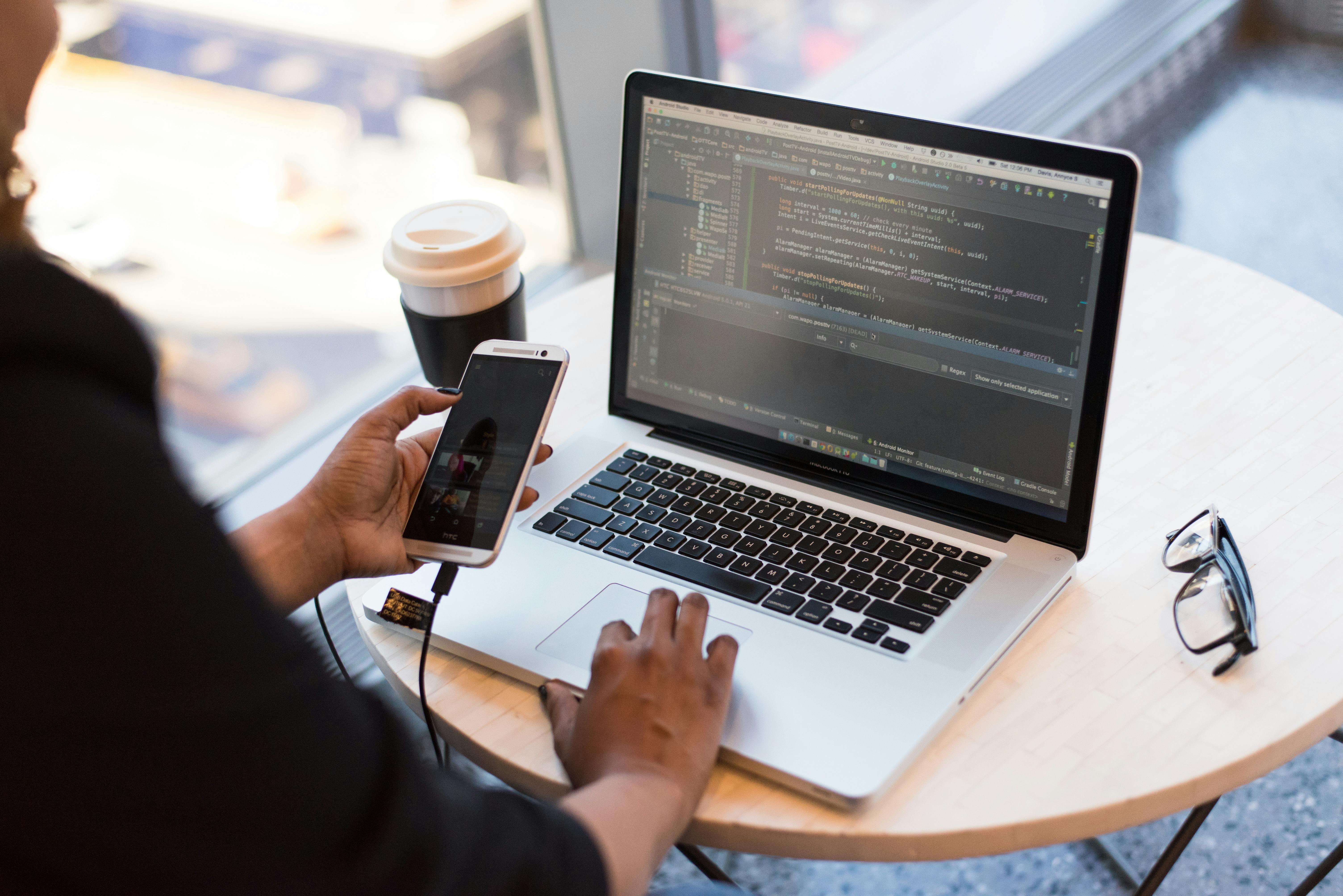 Smartphone with headphones and coffee on desk