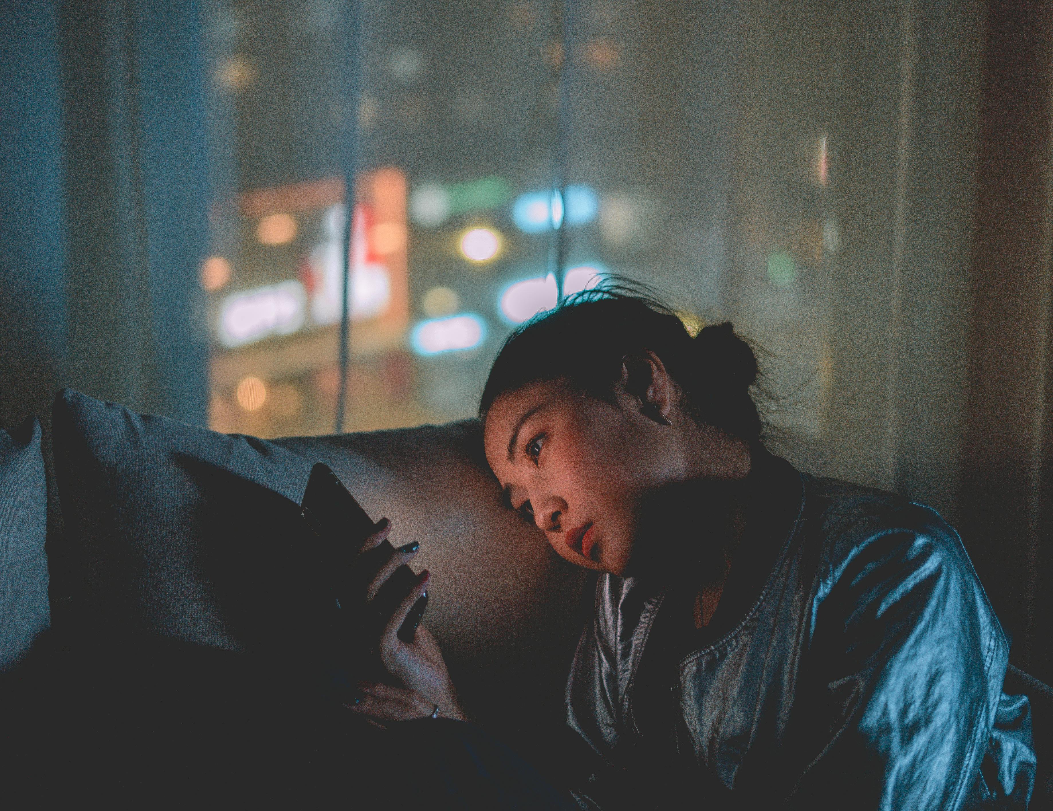 Person reading on phone screen looking tired