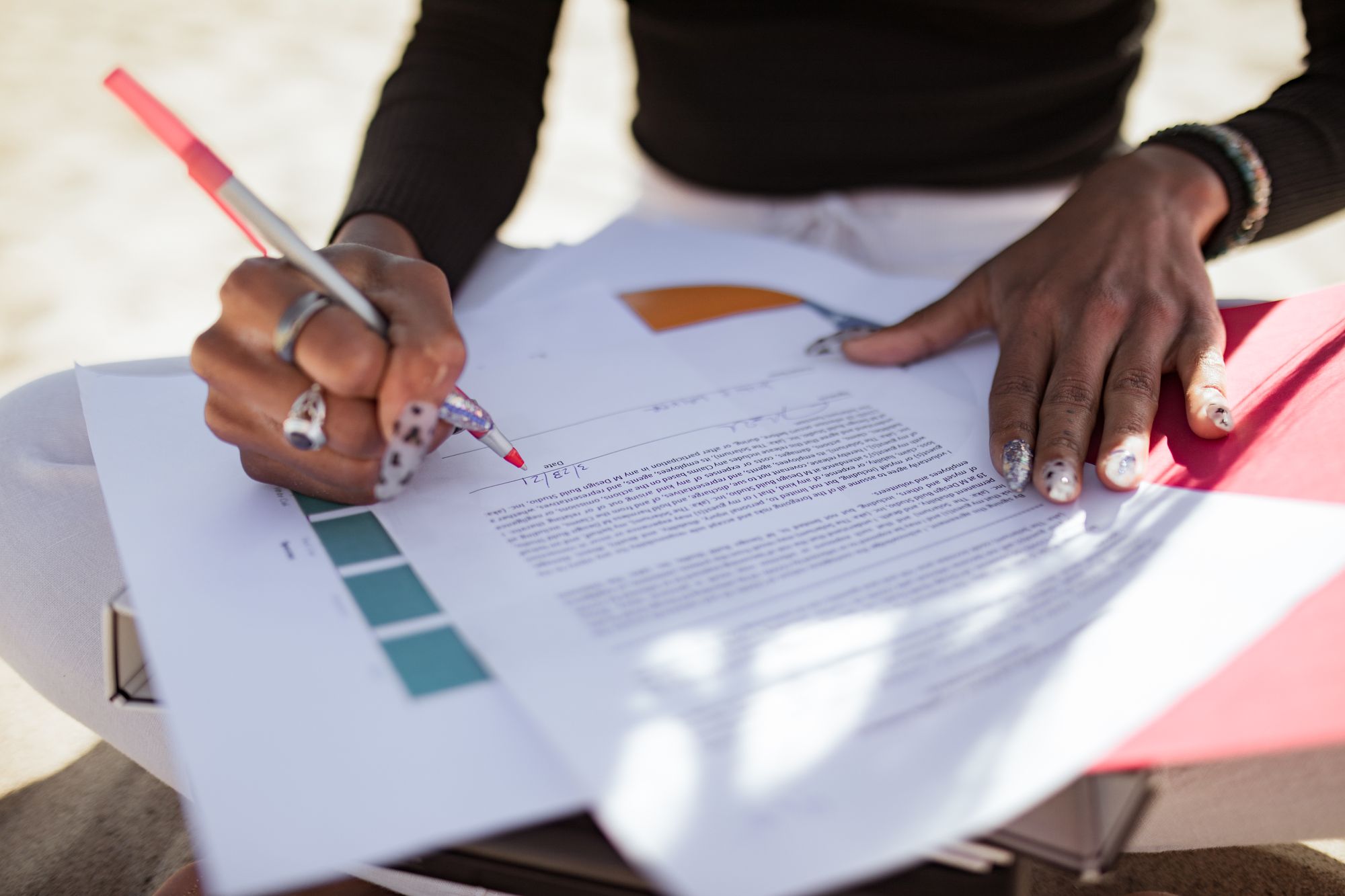 A person marking a printed page with a red pen