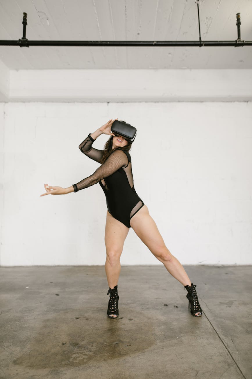 A woman in dance attire performs with a VR headset in an urban studio setting.